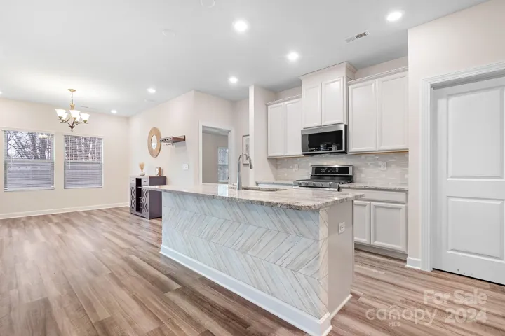 GORGEOUS kitchen with granite countertops, stainless steel appliances, and a walk-in pantry.
