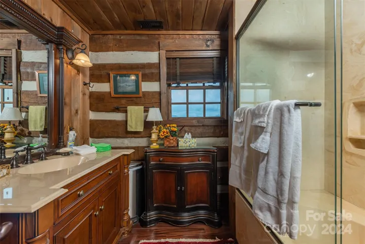 Upper level shared bath with wood accents, Toto toilet and cultured marble tub
