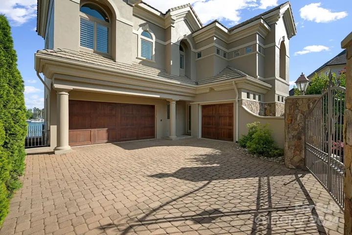 Gated entry to dual garage with storage, single car garage equipped with custom cabinets