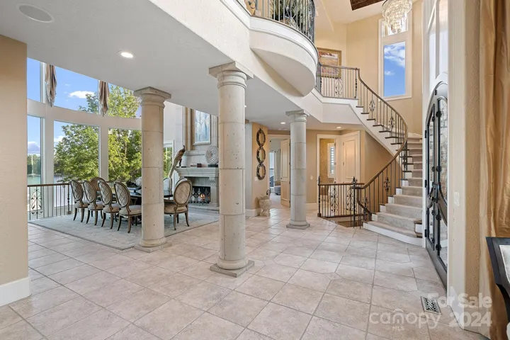 Soaring ceilings are accentuated by the elegant curved staircase