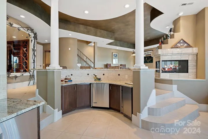 Wine room to the left is accentuated with custom iron work created by local artist, Ben Parrish. Lower level kitchenette features Viking dishwasher, mini fridge, Viking Professional microwave/convection oven, icemaker and Kegerator