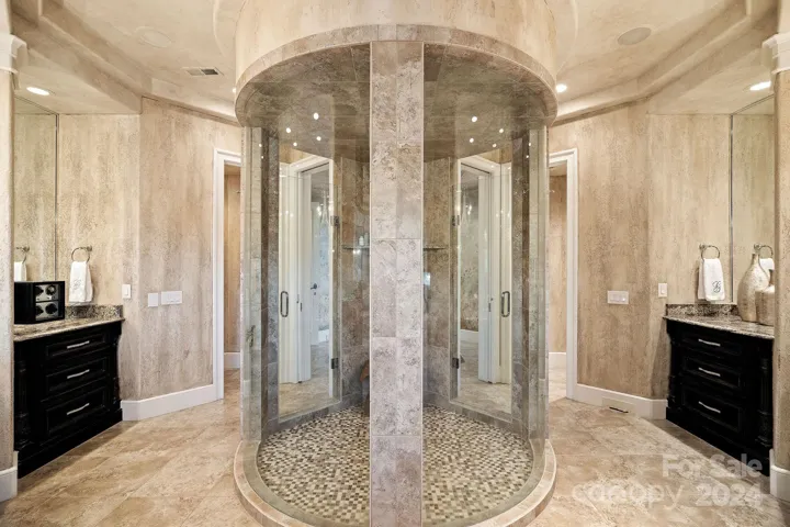 Enclosed curved glass shower with multiple sprayers