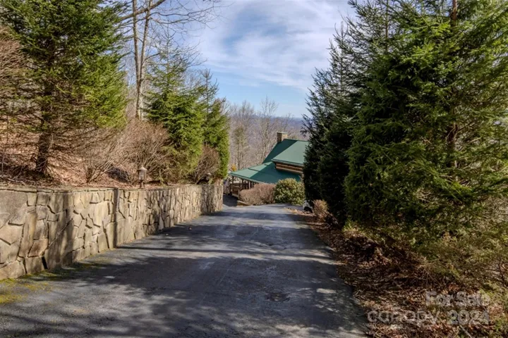 Paved driveway w/ mature landscaping & lighting
