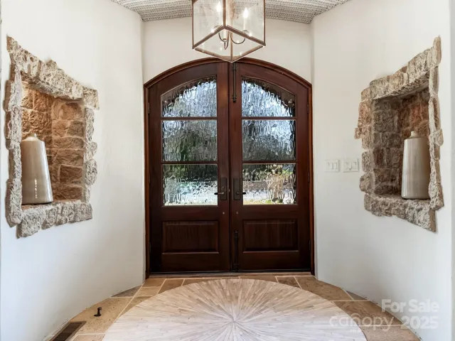 Interior photo of the entry foyer.  Foyer has basket woven ceiling w antique lantern lighting
