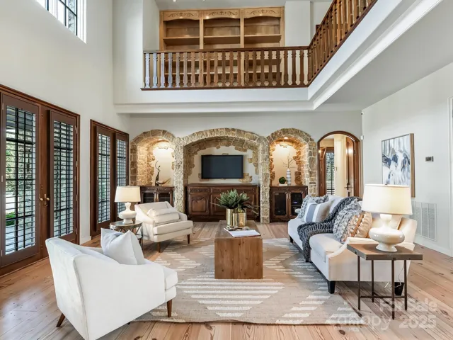 Living area with open ceiling overlooks the lower patio and the upper library.