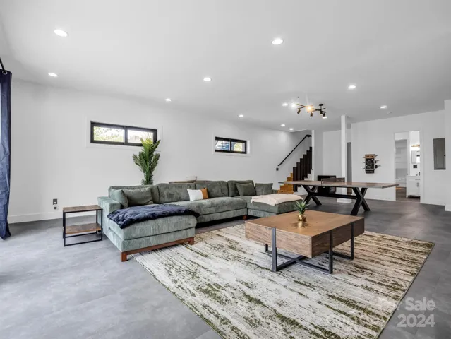 Massive entertainment room in the walk-out basement with a big screen TV, Ping Pong table, and arcade game.
