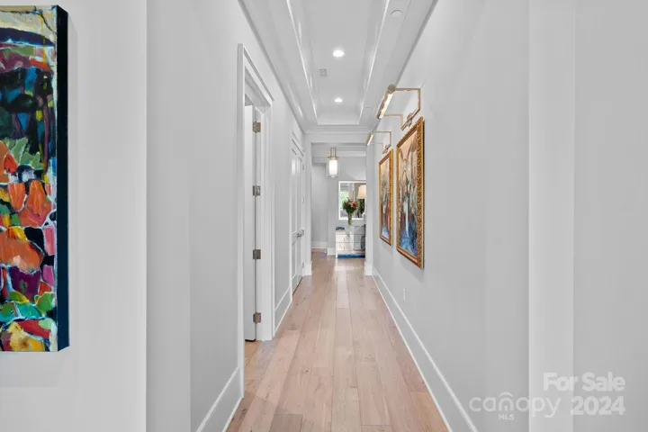 Gallery hallway with art lights leads to your indoor/outdoor living area.