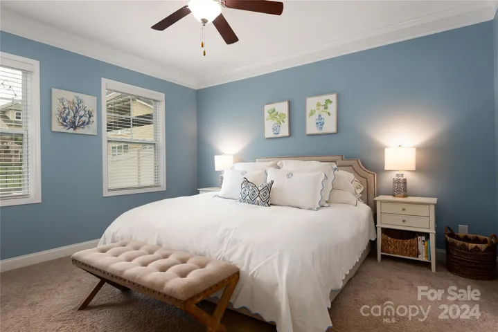 Spacious primary suite on main level with crown molding.
