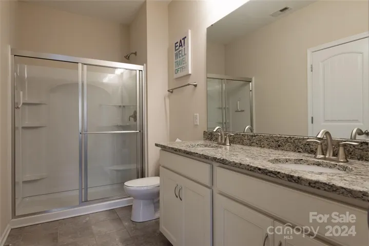Upstairs full bath with dual vanity and tile.
