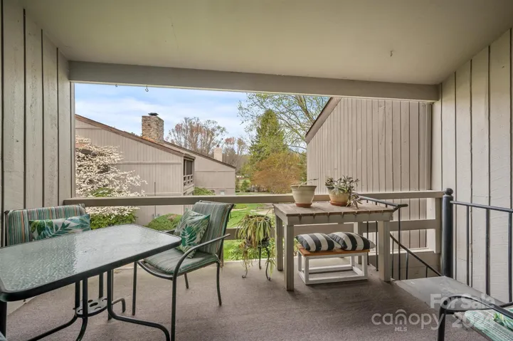 Covered deck/porch with spiral staircase overlooking beautiful landscaping