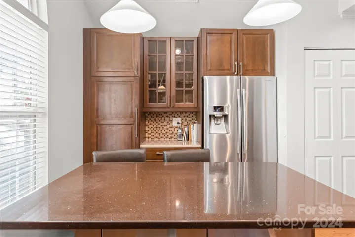 Silestone quartz countertops, convenient pull-out drawers, a counter-depth refrigerator, and an expansive island.
