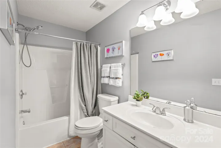 Second full bathroom with tub/shower combo and tile floors.