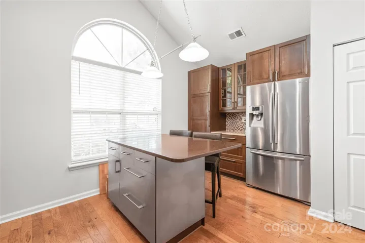 Custom cabinet pantry with pull outs, large island with plenty of storage and stainless steel fridge (conveys).