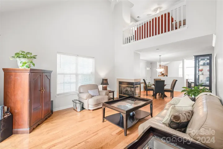 Vaulted great room with double-sided fireplace, hardwood floors and freshly painted.
