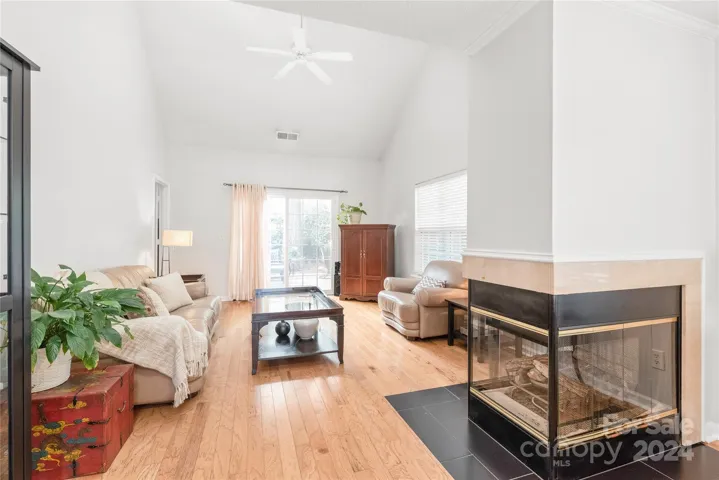 Spacious great room with double sided-fireplace and access to the secluded outdoor area in the back.