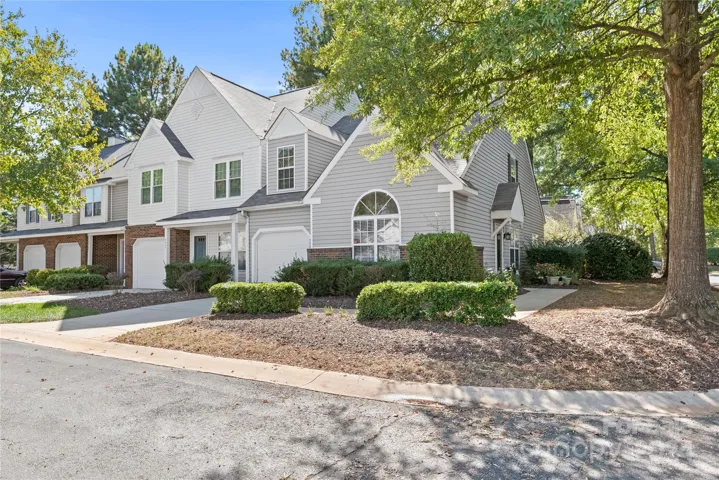 Private end unit featuring a side yard with mature trees and tranquil outdoor space.