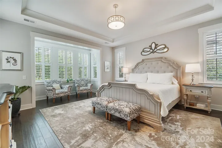 Retreat to the private primary suite, featuring a spacious walk-in closet, ensuite bath with a sink vanity, separate walk-in shower with bench, and custom tile detailing and in-suite laundry room for convenience.