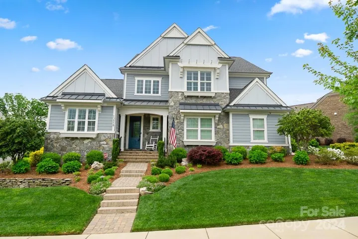 Meticulously landscaped front yard and stoned steps leading to entrance.