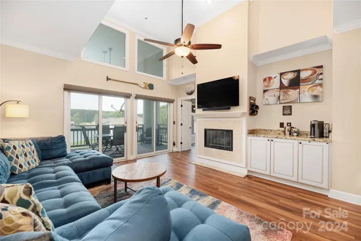 Great room with ceiling fan, fireplace, bar area and lots of natural light