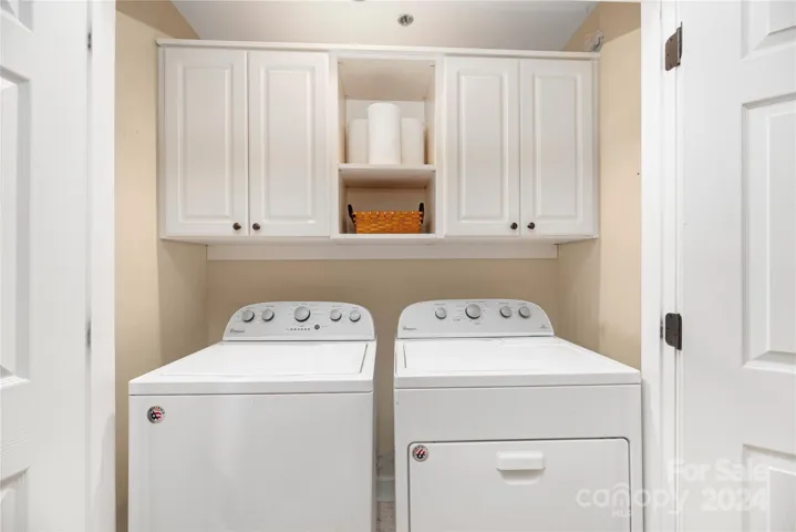 Laundry area with custom cabinets shelving/cabinets