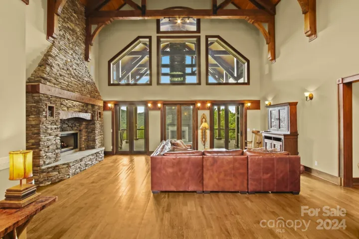 Grand Great Room with tall stone fireplace and windows framing the views