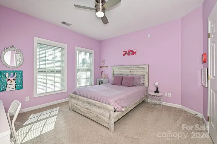 Bedroom #3 offers plentiful light, along with a modern fan and closet organizer.