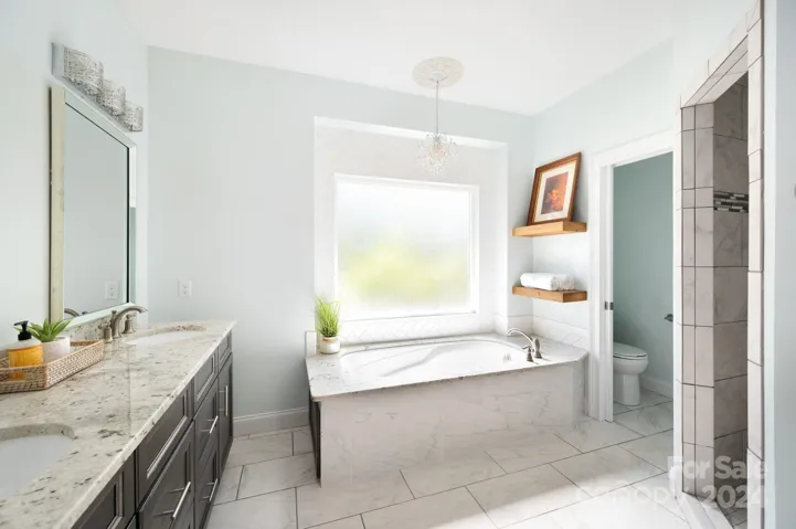 Main-level primary bedroom ensuite with granite countertops