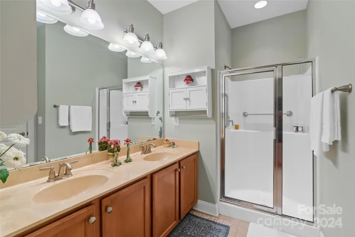En suite primary full bath with double sinks and walk in shower