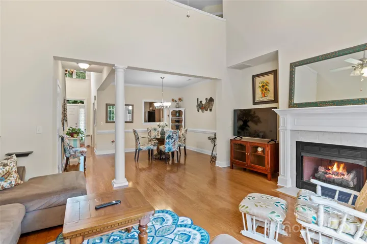Living room opens to dining room with soaring vaulted ceiling and gas fireplace