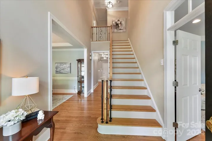 Two Story Foyer with Hardwood Floors, New Fixtures, Wood Treads on Staircase and Iron Balusters