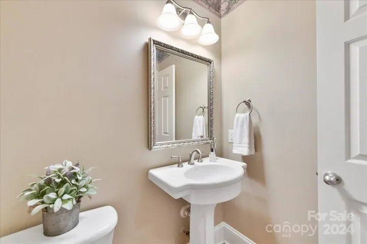 Powder Room with Wood Floors, Pedestal Sink and Framed Mirror