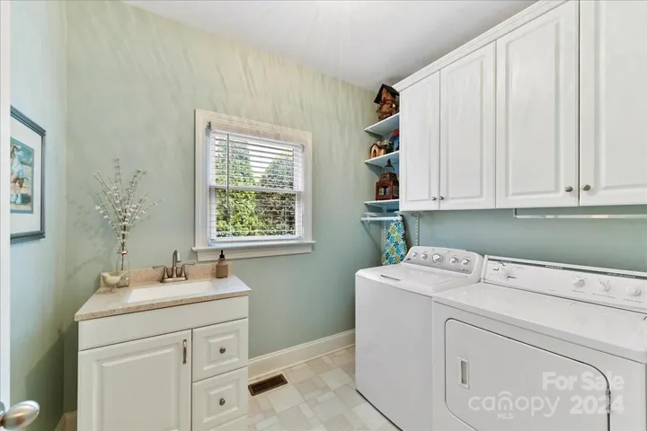 Laundry Room with Solid Surface Sink Cabinet, and built in shelving and additional Cabinets