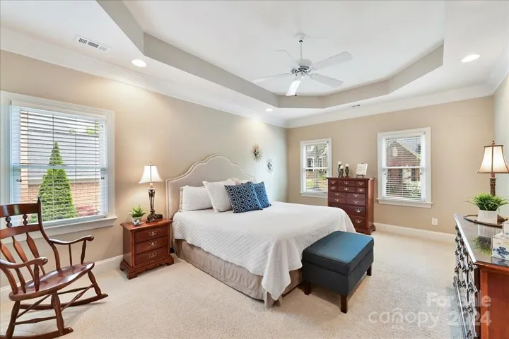 Upper Level Primary Bedroom Boasts of Tray Ceiling and Fan