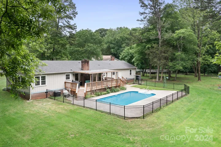 Ranch Style home with Sparkling pool, covered deck, studio guest house and backs to trees! Large Garden and almost 1 acre of land!