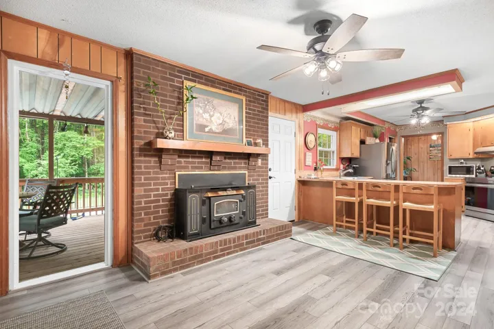 Den with Wood Burning woodstove insert. Large window to back deck and yard. Door to Back Deck and Pool area.