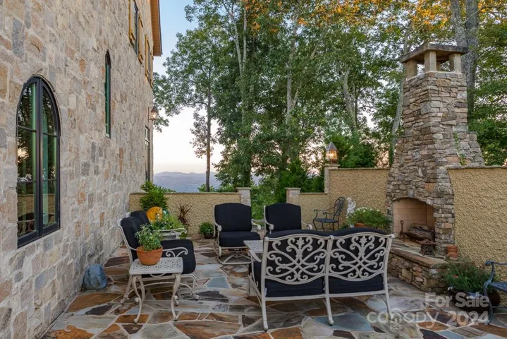 Marvelous outdoor terrace anchored by gas assisted wood burning fireplace and pebbledash walls.