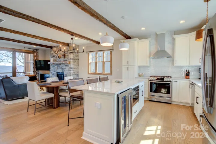 3rd level stylish kitchen features high-end quartz counters, soft close cabinetry, wine fridge, dual-fuel range & stainless exhaust