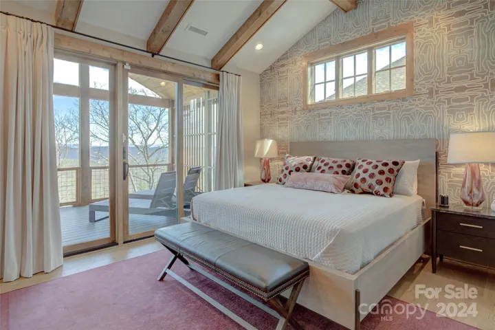 Primary bedroom suite on the top level, featuring vaulted ceilings and private deck