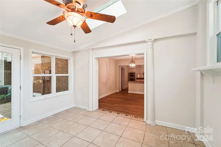 Sunroom with view into dining room, 2 skylights above.
