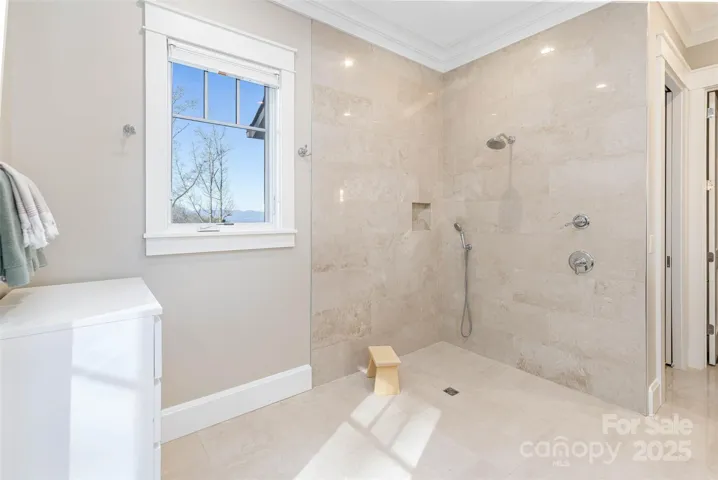 Primary en suite bath features radiant heated marble tile floors, separate open shower with zero entrance, crystal faucets, towel bars, paper holders and robe hook.