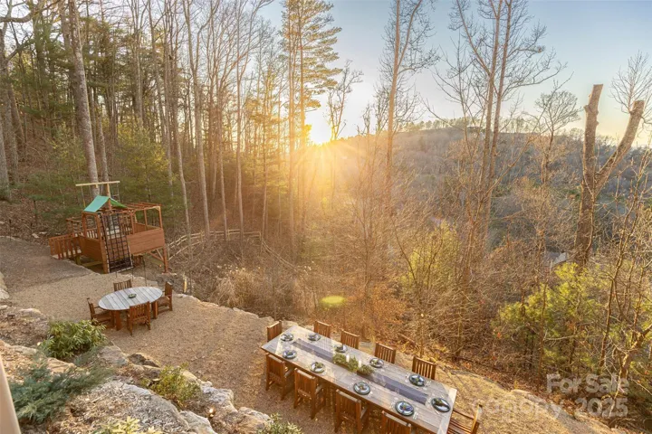 Soak in the seasons on multiple covered porches with retractable screens, decks & showstopping outdoor hardscape terraced yard. Send dinner down the exterior dumbwaiter before dining at the expansive teak table overlooking stunning sunset hues. Count the stars while roasting marshmallows in the cauldron fire pit. Playhouse, multiple seating areas and raised garden beds round out features.