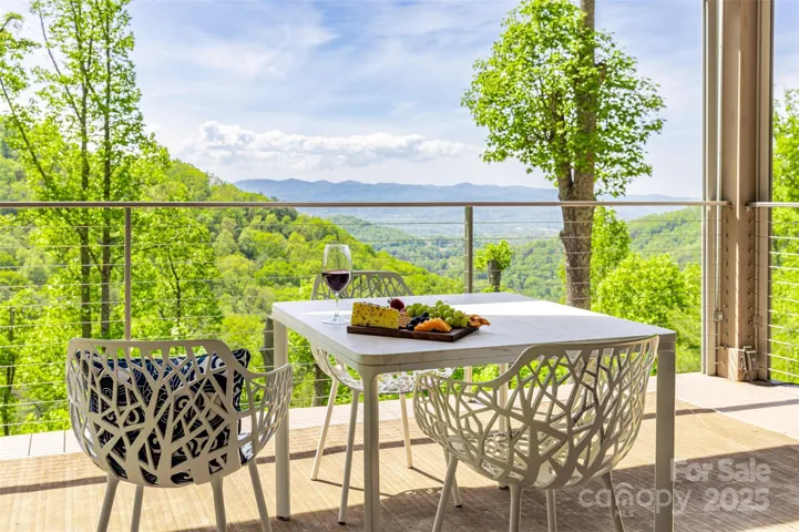 Long-range western views from this main level deck featuring cathedral ceilings, retractable screens, Azek maintenance-free decking and stainless steel cable railing.