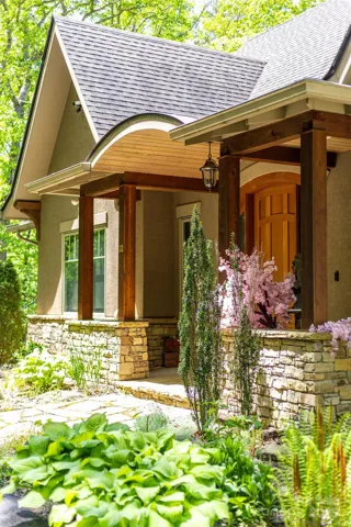 Main level entrance with a solid mahogany, custom-built, Prairie-style, arched entry door.