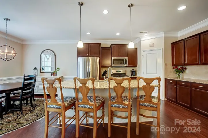 Engage your inner chef in this spacious kitchen boasting ss appliances, gas range, granite counters, center island with plenty seating, and walk-in pantry