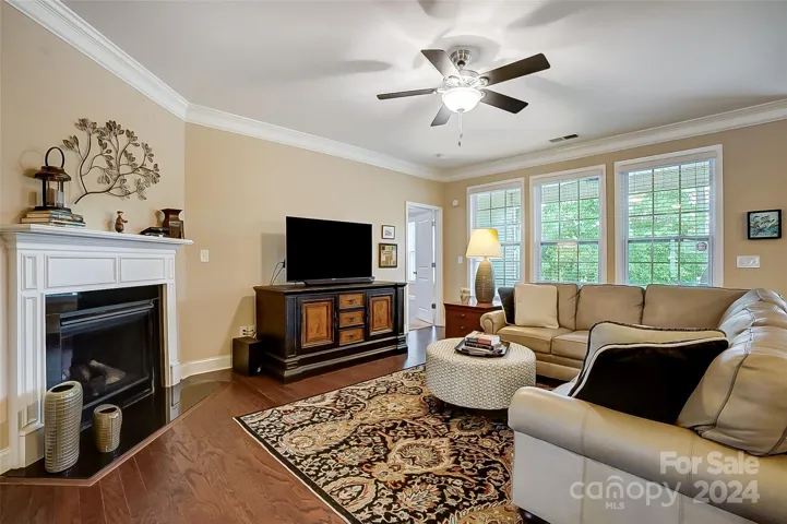 Great room with corner gas fireplace opening to chef's kitchen