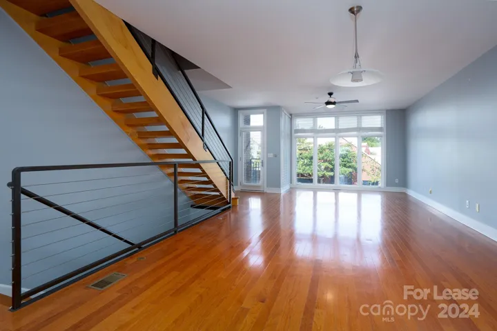 The second floor is a spacious and inviting open-concept dining and living area featuring floor-to-ceiling windows that flood the space with abundant natural light.