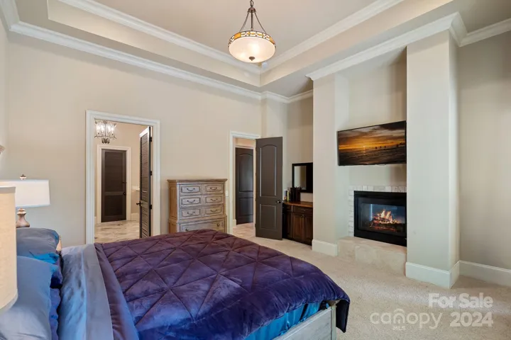 Lower level 2nd Primary Suite with lake view, gas fireplace, ensuite. Not pictured - ensuite connects to the home gym, which passes through to the recreation room.
