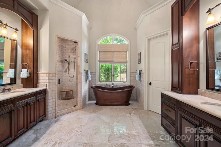 Primary ensuite "spa" with dual vanities, copper tub, large walk-in shower with rain and handheld shower heads.