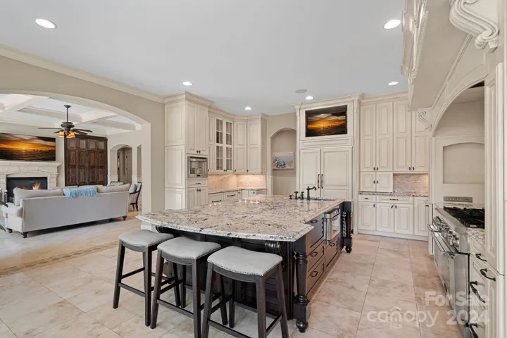 Gourmet kitchen with Thermador appliances: gas range/double oven/6-top with griddle/pot-filler; warming drawer and microwave built into island; Built-in espresso machine; Refrigerated beverage drawers in cabinets near espresso machine