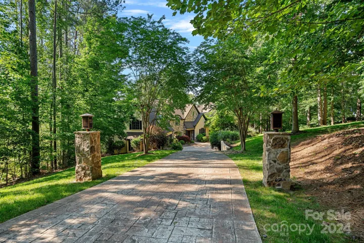 A meandering, stamped concrete driveway gives a stately entrance to the majestic home!